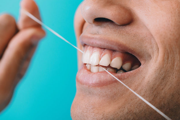 benefits of flossing daily (1) man exhibiting the benefits of flossing