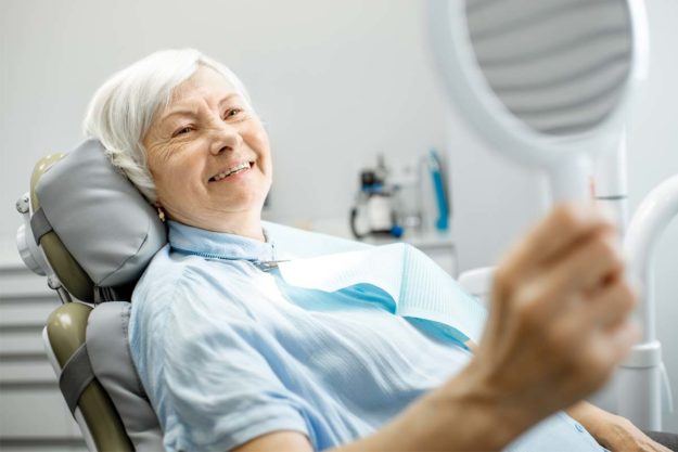 dental-implants (3) older woman looking at her dental implants