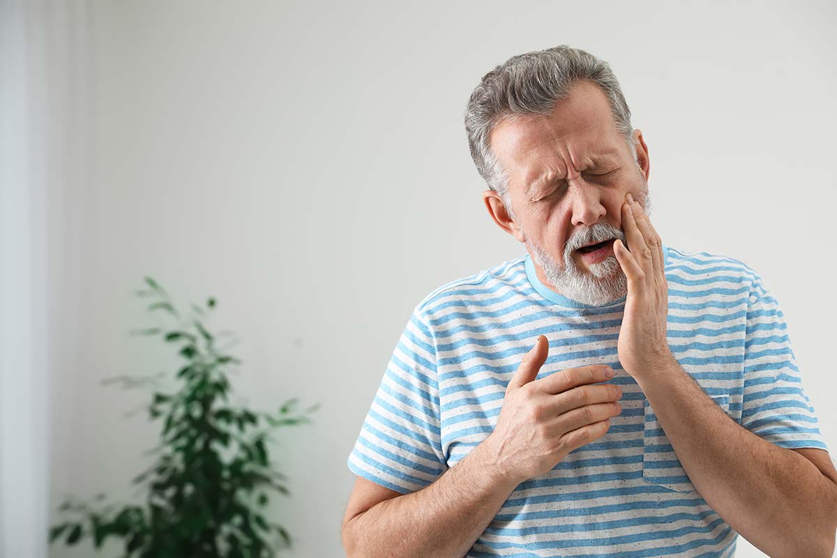 man holding jaw needing a dental appointment